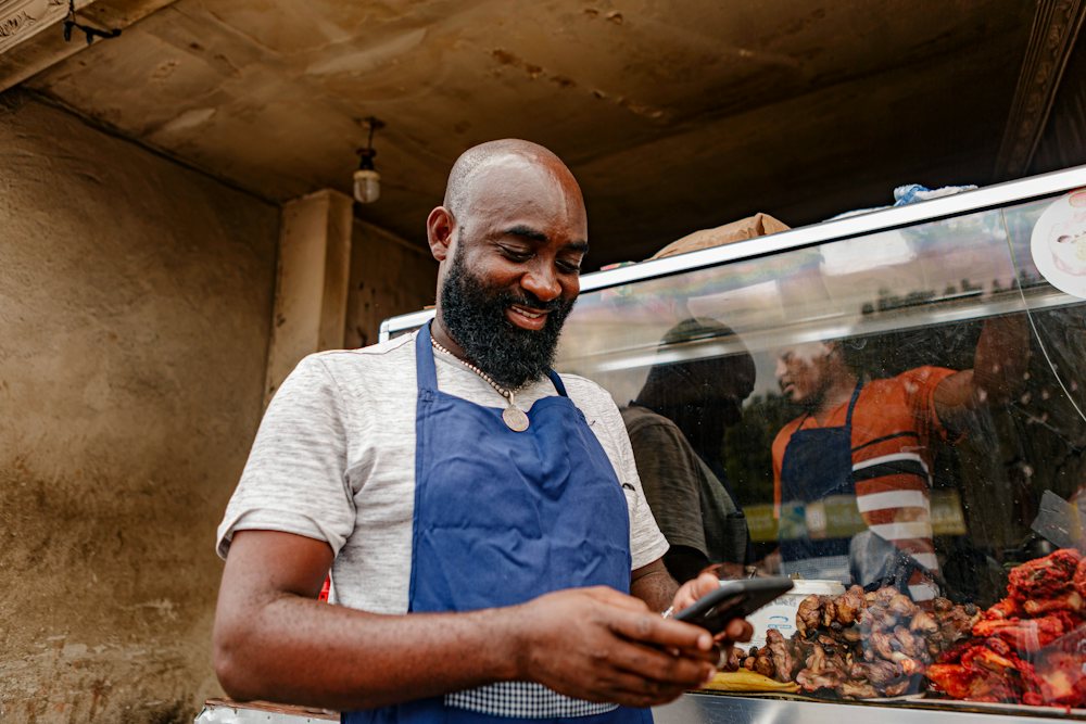 Business owner smiling while checking his phone