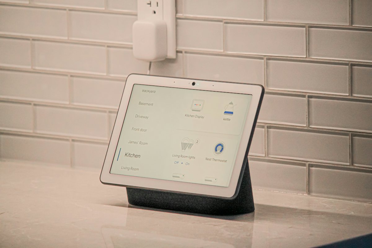 Pantalla inteligente sobre la barra de una cocina con pared de ladrillo blanco