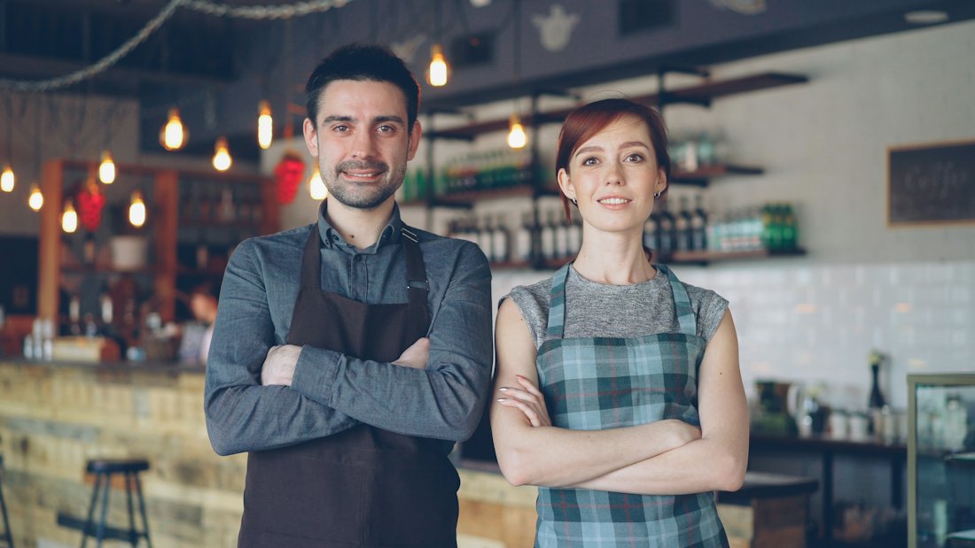 Coffee shop owners smiling at their business